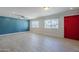 Spacious living room featuring wood-look tile flooring, a vibrant accent wall, and abundant natural light at 7135 W Flower St, Phoenix, AZ 85033