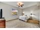 Cozy bedroom with neutral carpet, ceiling fan, and a large window with an exterior view at 7304 E Bent Tree Dr, Scottsdale, AZ 85266