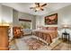 Cozy bedroom with a queen-sized bed, wood floors, a ceiling fan, and a picturesque window view at 7304 E Bent Tree Dr, Scottsdale, AZ 85266