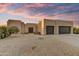 Contemporary home with a desert landscape and a three-car garage under a sunset sky at 7304 E Bent Tree Dr, Scottsdale, AZ 85266