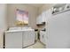 Laundry room featuring modern washer/dryer units and a window offering a view at 7304 E Bent Tree Dr, Scottsdale, AZ 85266