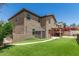Spacious backyard featuring a lush lawn, covered patio, storage shed, and beautiful landscaping at 7385 W Honeysuckle Dr, Peoria, AZ 85383