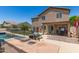 The backyard features a built-in outdoor kitchen and a pool with a metal fence surrounding it at 7385 W Honeysuckle Dr, Peoria, AZ 85383