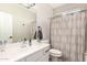 Clean bathroom with a single vanity, framed mirror, and shower with patterned curtains at 7385 W Honeysuckle Dr, Peoria, AZ 85383