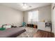 This bedroom has hardwood floors and a ceiling fan along with a dresser and many stuffed animals at 7385 W Honeysuckle Dr, Peoria, AZ 85383