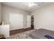 This bedroom has hardwood floors, a ceiling fan, and a view into the upstairs landing at 7385 W Honeysuckle Dr, Peoria, AZ 85383