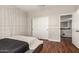 This bedroom has hardwood floors and a sliding door closet, with a view to the upstairs landing at 7385 W Honeysuckle Dr, Peoria, AZ 85383