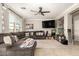Cozy living room with a plush sectional, large windows, and ceiling fan at 7385 W Honeysuckle Dr, Peoria, AZ 85383