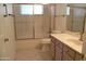 Bright bathroom featuring a tub-shower combo, neutral tile, and a vanity with a sink and gold-colored faucet at 9130 W Utopia Rd, Peoria, AZ 85382