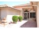 Inviting covered front porch featuring a decorative security door, lush landscaping, and a tiled walkway at 9130 W Utopia Rd, Peoria, AZ 85382