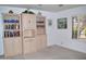 Cozy living room with built-in bookshelves, stylish decor, and shuttered window at 9130 W Utopia Rd, Peoria, AZ 85382