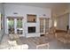 Bright living room boasts a fireplace, French doors, neutral color palette and carpet at 9130 W Utopia Rd, Peoria, AZ 85382