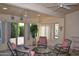 Bright sunroom with cozy seating, plants, and natural light from large windows at 9130 W Utopia Rd, Peoria, AZ 85382
