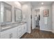 Elegant bathroom featuring double sinks, granite countertops, wood floors, and a walk-in closet at 9757 E Red Giant Dr, Mesa, AZ 85212