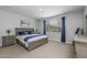 Cozy bedroom with a king-size bed, carpeted floor, and neutral gray walls with blue accents at 9757 E Red Giant Dr, Mesa, AZ 85212