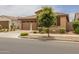 Attractive home features brick accents, a well-maintained lawn, and an attached two-car garage with a brick paver driveway at 9757 E Red Giant Dr, Mesa, AZ 85212