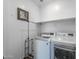 Functional laundry room featuring modern washer and dryer with ample storage space, shelving, and hanging rod at 9757 E Red Giant Dr, Mesa, AZ 85212