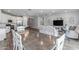 Expansive living area seamlessly connects the dining space and the kitchen, complete with white cabinetry and stainless appliances at 9757 E Red Giant Dr, Mesa, AZ 85212
