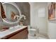 Stylish powder room with a unique vessel sink, round mirror, and modern fixtures at 9939 E Desert Jewel Dr, Scottsdale, AZ 85255