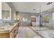A spacious bathroom featuring a glass shower, bathtub, double vanity, and floor-to-ceiling tile at 9939 E Desert Jewel Dr, Scottsdale, AZ 85255