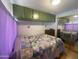 Bedroom featuring green cabinets, mirrored closet and cozy bedspread at 1004 S Kiowa Cir, Apache Junction, AZ 85119