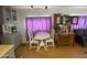 Bright kitchen with wooden floors, vintage cabinet, and dining table with purple curtains at 1004 S Kiowa Cir, Apache Junction, AZ 85119