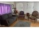 Living room boasts a comfortable gray sofa, chairs, and natural light from the window at 1004 S Kiowa Cir, Apache Junction, AZ 85119