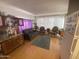 A view of the living room, with hardwood floors, gray sofa, chairs, and natural light from the window at 1004 S Kiowa Cir, Apache Junction, AZ 85119