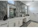 Modern bathroom featuring double vanity, with stone accent wall, and a glass enclosed shower at 11045 N Hershey St, Surprise, AZ 85388