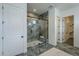 Modern bathroom featuring glass enclosed shower with stone accents, and view to walk-in closet at 11045 N Hershey St, Surprise, AZ 85388