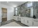 Modern bathroom featuring double vanity, with stone accent wall, and view to large shower at 11045 N Hershey St, Surprise, AZ 85388