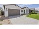 Charming home featuring a paver driveway and lush artificial turf lawn at 11045 N Hershey St, Surprise, AZ 85388
