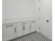 Well-lit laundry room featuring storage cabinets and a stylish patterned floor at 11045 N Hershey St, Surprise, AZ 85388
