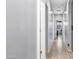 Well lit hallway features white walls and doors with light-colored wood-look tile at 11742 W Chase Ln, Avondale, AZ 85323