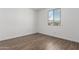 Sunlit bedroom with wood-look tile flooring and a view from the window at 12381 W Marguerite Ave, Avondale, AZ 85323
