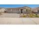 Attractive home exterior with a three-car garage and decorative landscaping at 12381 W Marguerite Ave, Avondale, AZ 85323