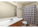 Cozy bathroom featuring a single sink vanity and a shower-tub combo with a patterned curtain at 12606 W Scotts Dr, El Mirage, AZ 85335