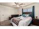 Comfortable bedroom featuring a ceiling fan, dark furniture and a window allowing for natural light at 12606 W Scotts Dr, El Mirage, AZ 85335