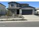 Two-story home with gray stucco, stone accents, gray garage door and desert landscaping at 12816 N 172Nd Dr, Surprise, AZ 85388
