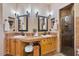 Bathroom featuring double sinks, framed mirrors, sconces, tiled counter, and glass enclosed shower at 13250 N 13Th Ln, Phoenix, AZ 85029