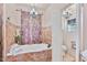 Elegant bathroom featuring a bathtub with tile surround and decorative chandelier lighting at 13250 N 13Th Ln, Phoenix, AZ 85029
