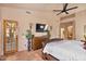Bedroom features a bed, dresser with TV, ceiling fan, sconces, and access to the patio at 13250 N 13Th Ln, Phoenix, AZ 85029