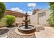 Charming courtyard fountain with seating and gravel surround, providing a tranquil outdoor space at 13250 N 13Th Ln, Phoenix, AZ 85029