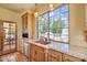 Bright kitchen features custom cabinets, a copper sink, a granite countertop, and a large window at 13250 N 13Th Ln, Phoenix, AZ 85029
