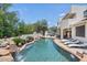 Stunning pool area with a rock waterfall, lush greenery, and comfortable lounge chairs for ultimate relaxation at 13250 N 13Th Ln, Phoenix, AZ 85029