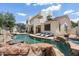 Inviting pool with a rock waterfall, set against the backdrop of a well-maintained home and scenic outdoor space at 13250 N 13Th Ln, Phoenix, AZ 85029