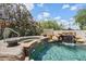 Relaxing pool area with a rejuvenating waterfall feature, hot tub, and vibrant flowers, perfect for unwinding outdoors at 13250 N 13Th Ln, Phoenix, AZ 85029