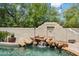 Beautiful pool with rock waterfall, surrounded by lush landscaping at 13250 N 13Th Ln, Phoenix, AZ 85029