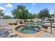 Beautiful pool and spa combination with a rock waterfall feature, surrounded by lush landscaping for outdoor enjoyment at 13250 N 13Th Ln, Phoenix, AZ 85029