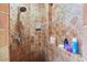 Shower with mosaic tile surround, shower head, and built in shelf with bath and body accessories at 13250 N 13Th Ln, Phoenix, AZ 85029